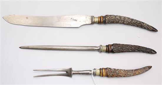 Victorian antler handles three piece carving set and a pair of silver mounted glass knife rests(-)